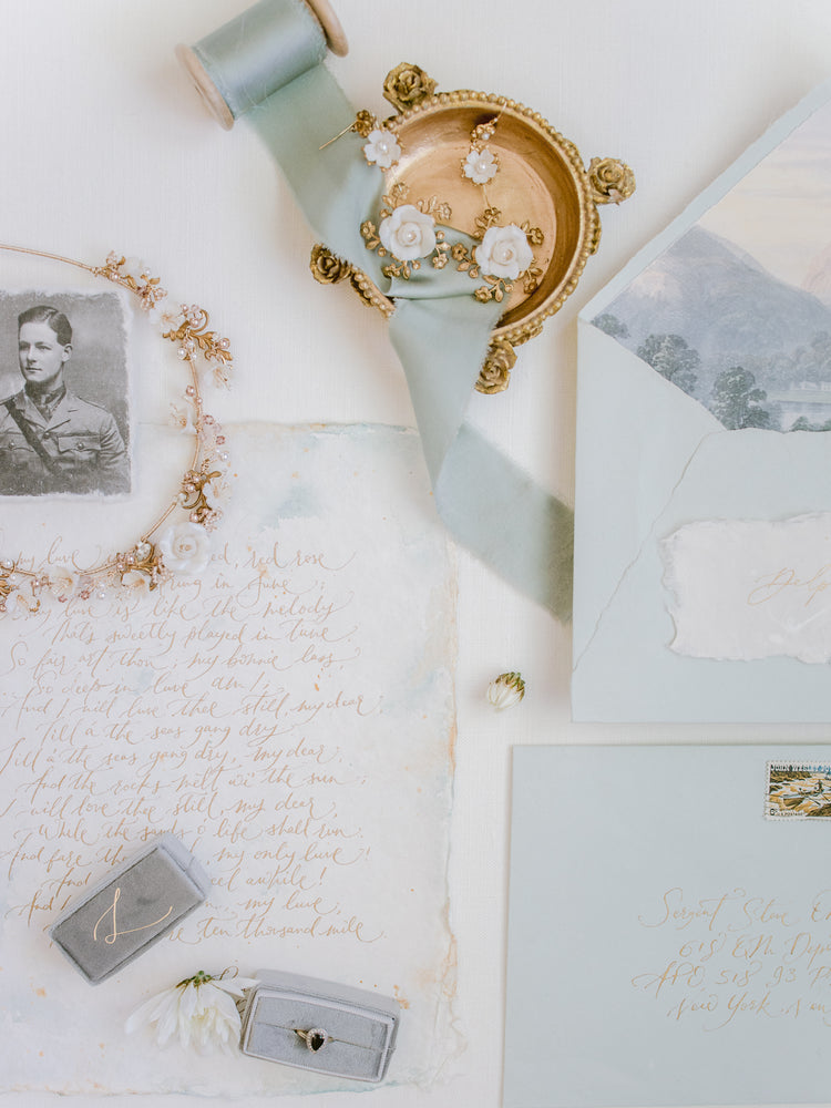 pale blue wedding stationery and vintage like gold wedding accessories and jewellery
