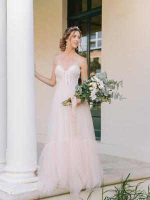 
            
                Load image into Gallery viewer, bride wearing a floral wedding crown with blush pearls with  gold drop earrings holding a vintage roses arm bouquet
            
        