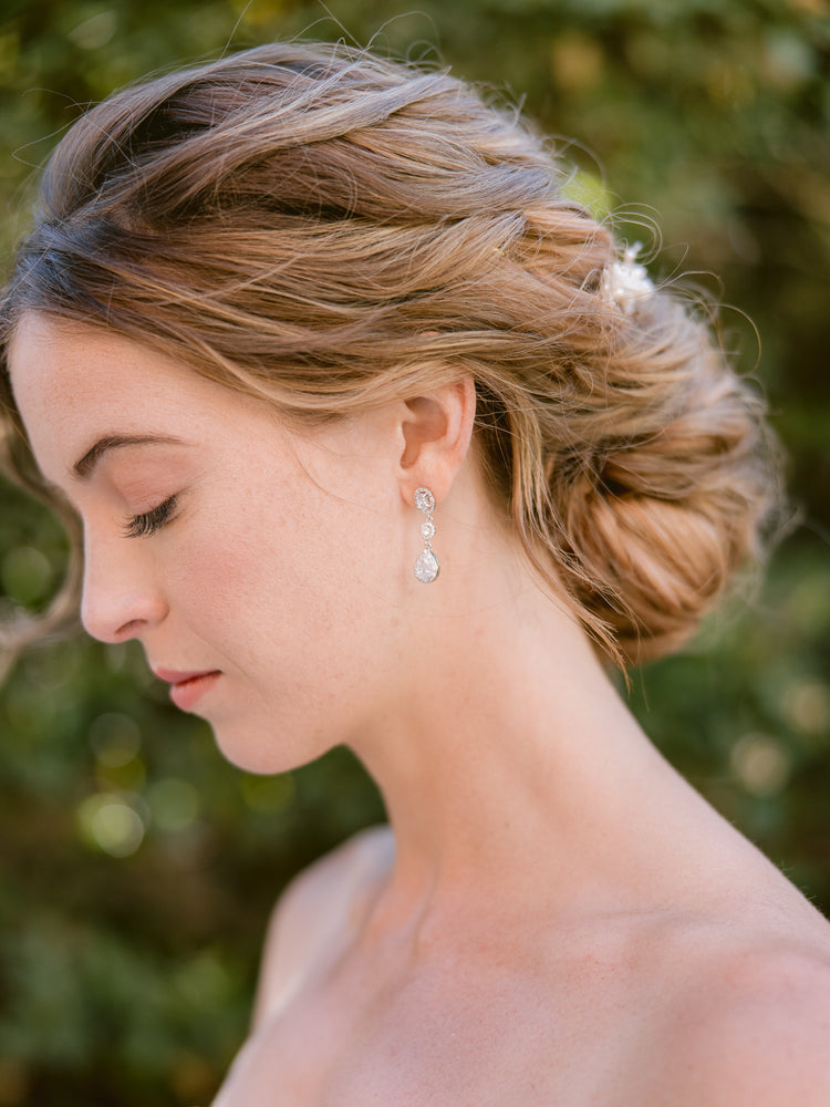 bride wearing silver crystal long drop earrings with romantic updo and silver headpiece