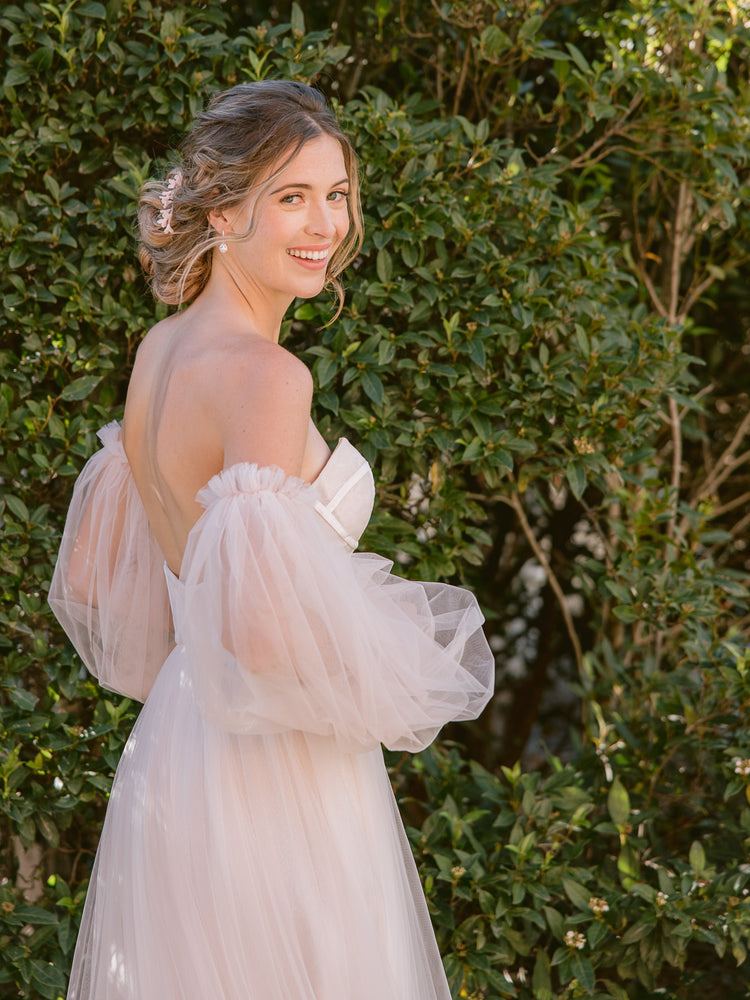 
            
                Charger l&amp;#39;image dans la galerie, Smiling bride in a blush romantic wedding gown, wearing blush flower hair pins and silver crystal drop earrings 
            
        