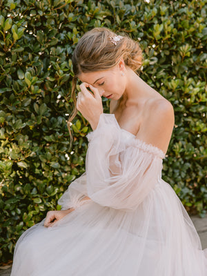 
            
                Load image into Gallery viewer, Bride wearing a romantic sleeved blush tulle wedding gown and rose gold hair accessories and jewellery with crystals and pearls
            
        