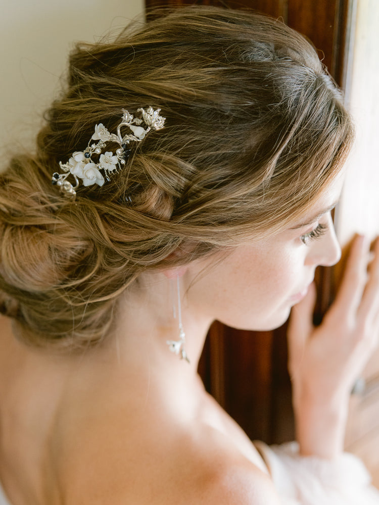 
            
                Load image into Gallery viewer, Bride wearing updo with silver bridal hair comb with roses, flowers, and blue pearls and crystals as something blue
            
        